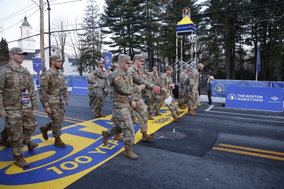 Military marchers set out from Hopkinton to start the 128th Boston Marathon