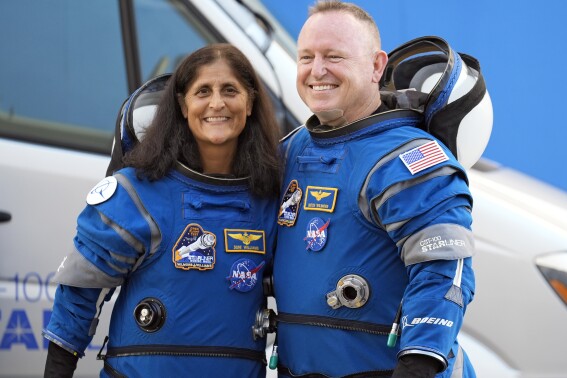 NASA astronauts who will spend extra months at the space station are veteran Navy pilots